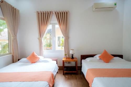 a bedroom with two beds and a window at Thai Tan Tien Hotel in Phu Quoc