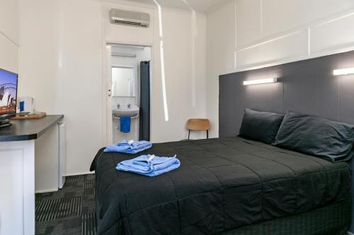 a bedroom with a bed with blue towels on it at Tinman Roadhouse in Napperby