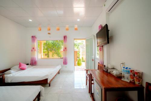 a bedroom with two beds and a television in it at Thai Tan Tien Hotel in Phu Quoc