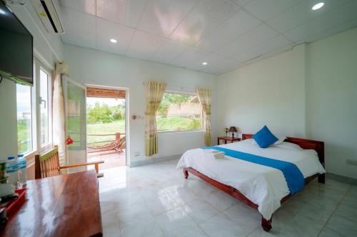 a bedroom with a bed and a table and window at Thai Tan Tien Hotel in Phu Quoc