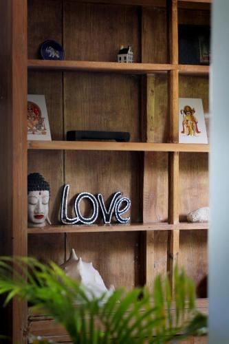 a wooden shelf with the word love written on it at The Apartments Canggu in Canggu