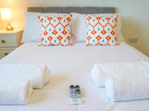 a bedroom with a white bed with two slippers on it at Modern 3-Bed Home with Garden & Free Parking - Pass the Keys in Nottingham