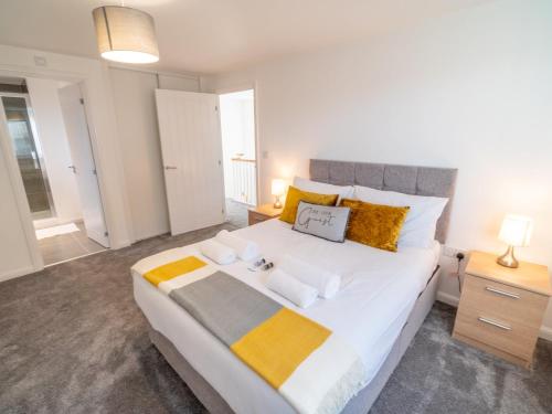 sypialnia z dużym łóżkiem z żółtymi i szarymi poduszkami w obiekcie Pass the Keys Centrally located beautiful 3 bed new build home w Nottingham