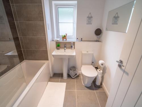 a bathroom with a sink and a toilet and a tub at Pass the Keys Centrally located beautiful 3 bed new build home in Nottingham