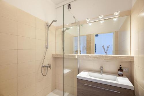 une salle de bain avec un lavabo et une douche dans l'établissement Le Saint Jean - Appt avec vue sur lentrée du Vieux Port, à Marseille