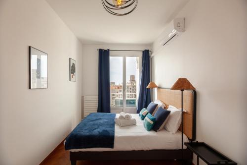 - une chambre avec un lit doté de rideaux bleus et d'une fenêtre dans l'établissement Le Saint Jean - Appt avec vue sur lentrée du Vieux Port, à Marseille