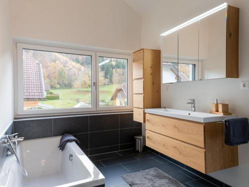 łazienka z wanną, umywalką i oknem w obiekcie Tasteful holiday home near Ossiacher lake w mieście Töbring