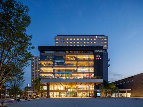 an office building with lights on at night at THE BLOSSOM KUMAMOTO in Kumamoto
