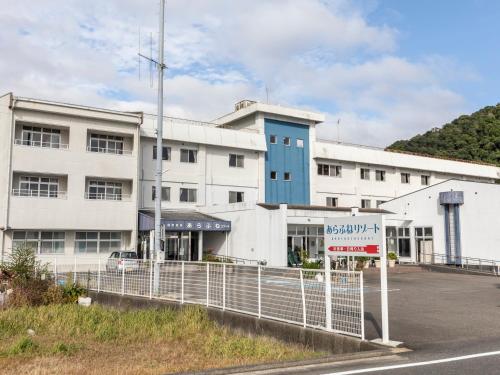 a large white building with a sign in front of it at Arafune Resort in Shimo-tahara