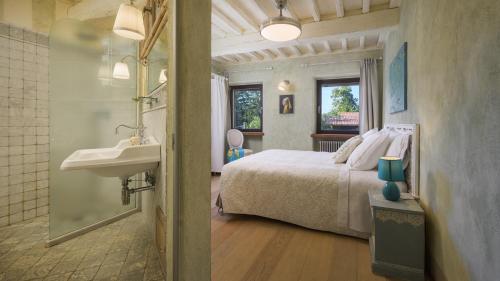 Un dormitorio con una cama y un lavabo y un baño. en LA DAMA DEL BOSCO 8&3, Emma Villas, en Capriglia