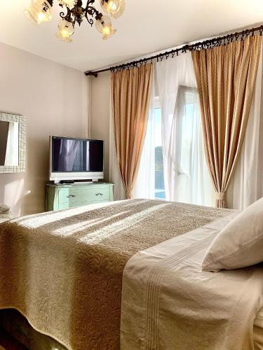 a bedroom with a large bed and a television at Holiday Home Endi in Unešić