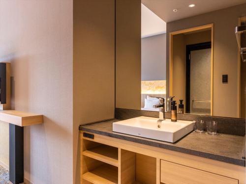 a bathroom with a sink and a mirror at THE BLOSSOM KUMAMOTO in Kumamoto