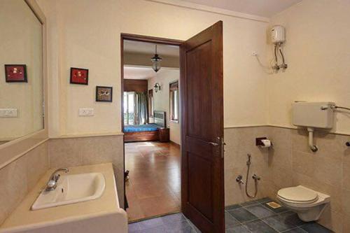 La salle de bains est pourvue d'un lavabo et de toilettes. dans l'établissement Great 5Bhk Villa Alibaug, à Alibaug