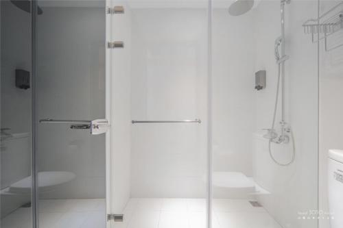 biała łazienka z prysznicem i umywalką w obiekcie 山鄰山林青年文旅 forest 3030 hostel w mieście Yuli