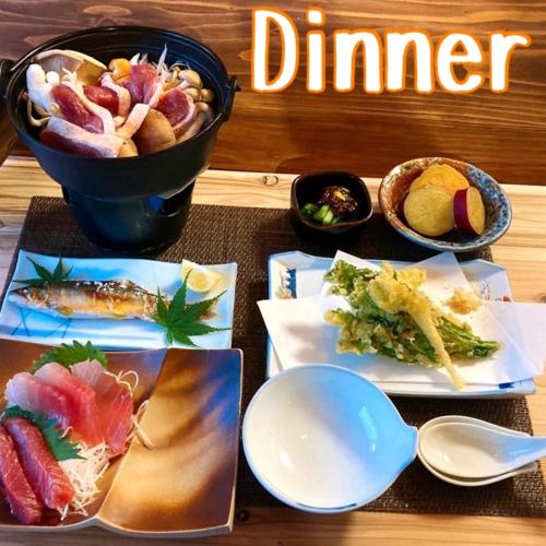 - une table avec des assiettes de nourriture et un bol de nourriture dans l'établissement Minshuku Sumiya, à Tanabe