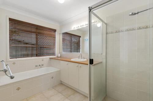 a bathroom with a tub and a sink and a shower at 21 David Street Noosa Heads in Noosa Heads