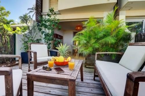 un patio con sillas y una mesa con fruta. en La villa Caroline - La Saline les Bains en La Saline les Bains