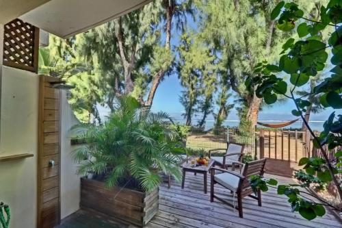 una terraza con mesa, sillas y árboles en La villa Caroline - La Saline les Bains en La Saline les Bains