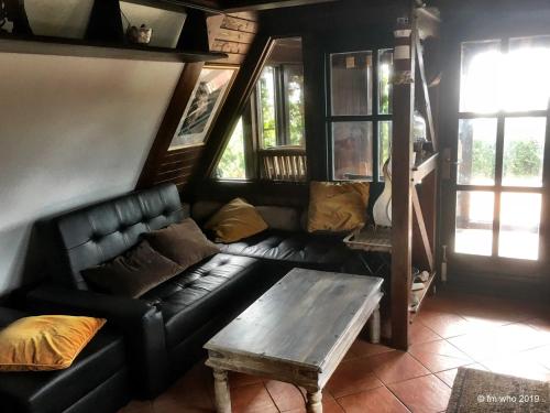 a living room with a black leather couch and a table at Hoefthus 1 in Alt Reddevitz