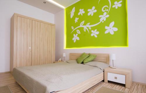 1 dormitorio con 1 cama con una pintura verde en la pared en Régiposta Studio, en Budapest