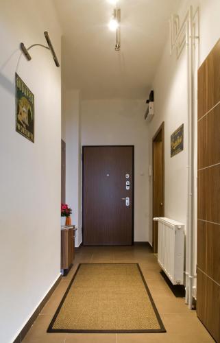 ein Flur mit einer braunen Tür und einem Teppich in der Unterkunft Régiposta Studio in Budapest