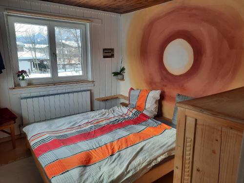 1 dormitorio con 1 cama en una habitación con ventana en Bauernhaus im Permakultur-Garten, en Sankt Johann in Tirol