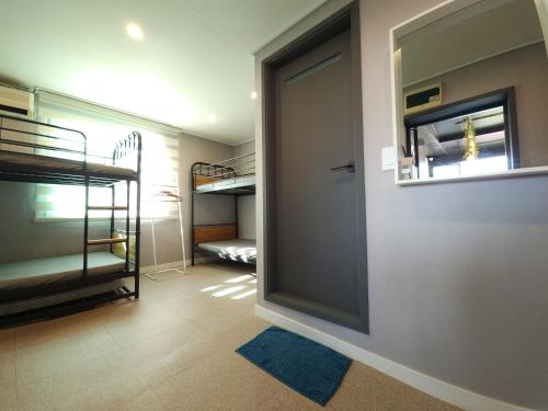 a room with a door and a room with bunk beds at OYO Hostel Dongdaemun1 in Seoul