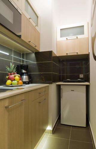eine Küche mit Holzschränken und Obst auf der Theke in der Unterkunft Régiposta Studio in Budapest