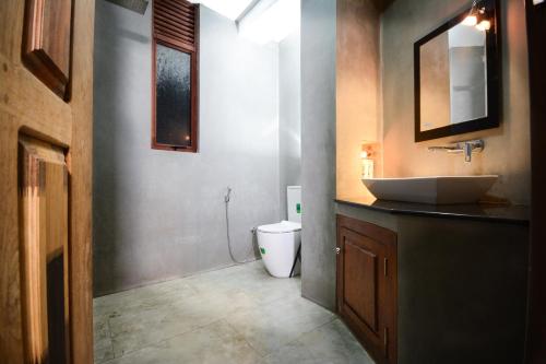 a bathroom with a sink and a toilet at SEVENTY SEVEN GALLE in Galle