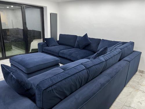 un gran sofá azul en la sala de estar en Penthouse Style Luxury 2 Bedroom House has Hot-Tub, extra fees apply en Birmingham