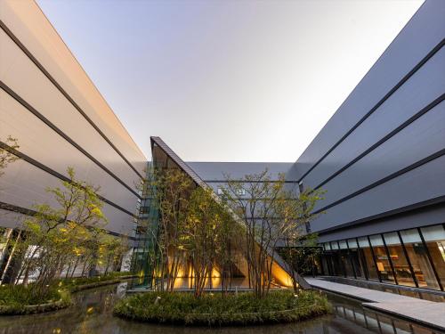 an office building with trees in front of it at THE BLOSSOM KUMAMOTO in Kumamoto