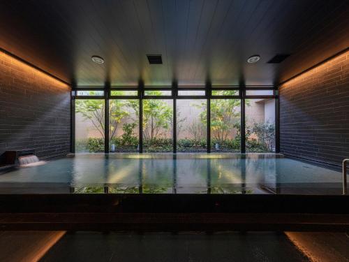 a room with a swimming pool with a large window at THE BLOSSOM KUMAMOTO in Kumamoto