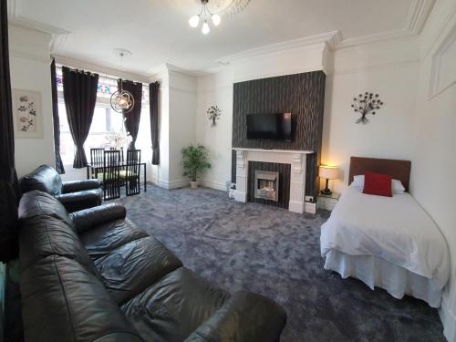 a living room with a couch and a fireplace at Norwyn Court Holiday Apartments in Blackpool