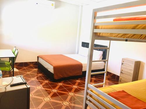 a bedroom with a bunk bed and a desk at Saeng Tai Amphawa in Samut Songkhram