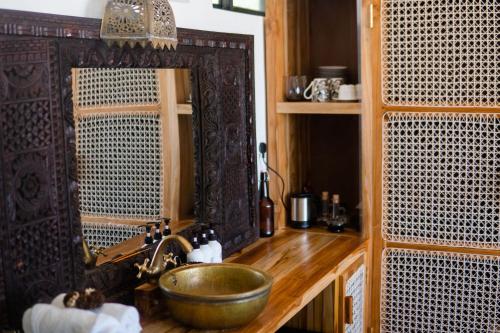 a bathroom with a sink and a mirror at CoCo Tree House @ Kima Zanzibar, Unique stay in Bwejuu