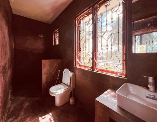 łazienka z toaletą, umywalką i oknem w obiekcie Freshi Residence w mieście Jambiani