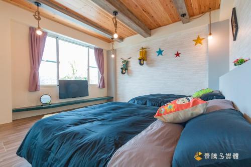 a bedroom with two beds and a tv in it at Longer Homestay in Taitung City