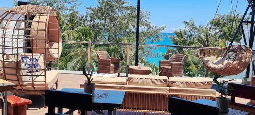 a balcony with a couch and chairs and a view of the ocean at The Paragon Boracay Suites in Boracay