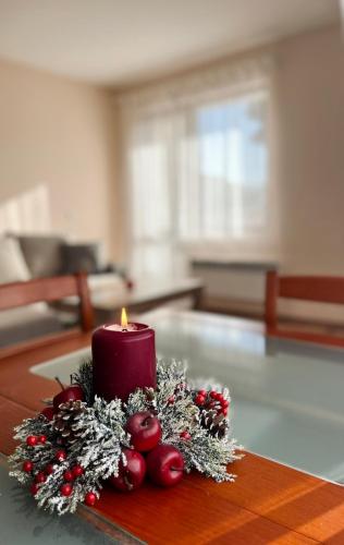 a candle on a table with christmas decorations on it at Prime Apartments in Bansko