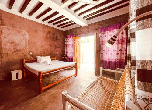 mały pokój z łóżkiem i oknem w obiekcie Freshi Residence w mieście Jambiani