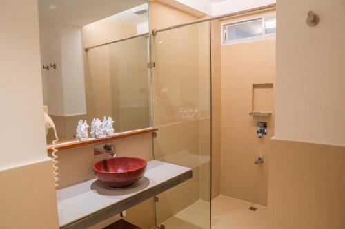 a bathroom with a glass shower with a red bowl on a counter at The Paragon Boracay Suites in Boracay