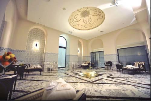 a lobby with a large room with tables and chairs at Royal Hotel Oran - MGallery Collection in Oran