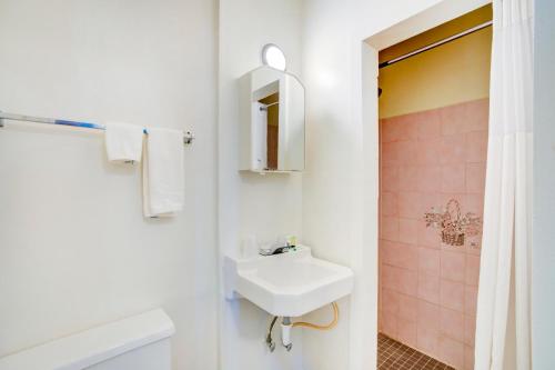 y baño blanco con lavabo y ducha. en Rose's Motel en Willcox