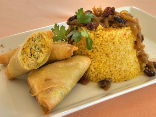 a plate of food with corn and a burrito at Villa Guadalupe in Málaga