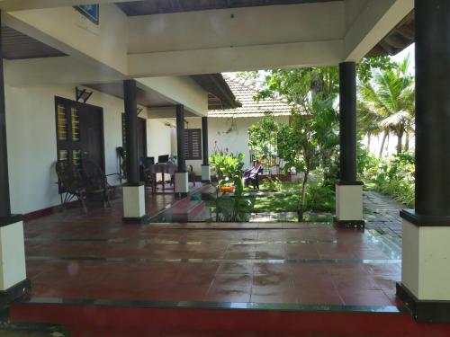 an empty courtyard of a house with tables and chairs at Marari SeaLap Beach Villas in Mararikulam