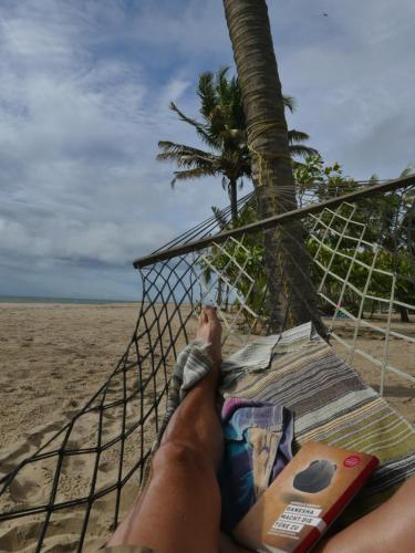 a person laying in a hammock on the beach at Marari SeaLap Beach Villas in Mararikulam