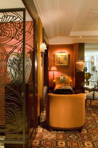 a hotel room with a couch and a chair at Royal Hotel Oran - MGallery Collection in Oran