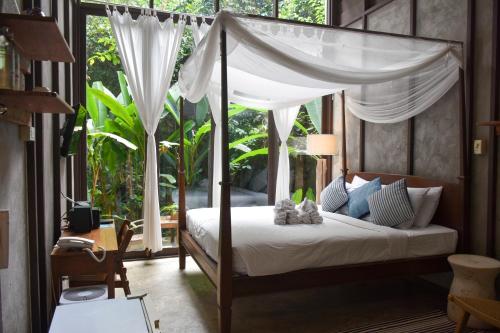 a bedroom with a bed with a canopy at Proud Phu Fah Maerim Resort in Mae Rim