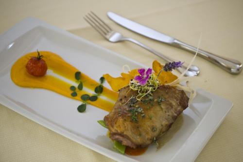 a white plate with a piece of meat and vegetables at Villa Guadalupe in Málaga