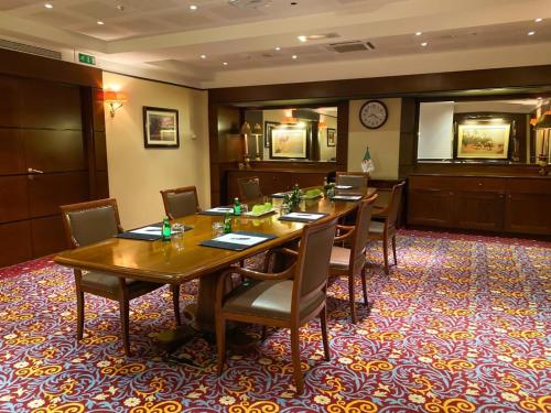 a conference room with a long wooden table and chairs at Royal Hotel Oran - MGallery Collection in Oran